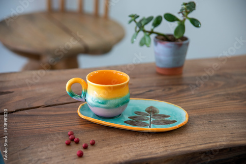 colorful handmade ceramic coffee cups on wooden table 