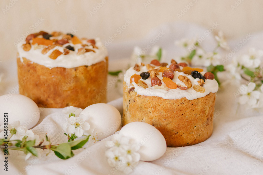 Delicious festive Easter cake, Easter eggs and blossoming twigs of apple tree on linen light background, easter celebration concept Delicious festive Easter cake, Easter eggs and blossoming twigs of apple tree on linen light background, easter celebration concept