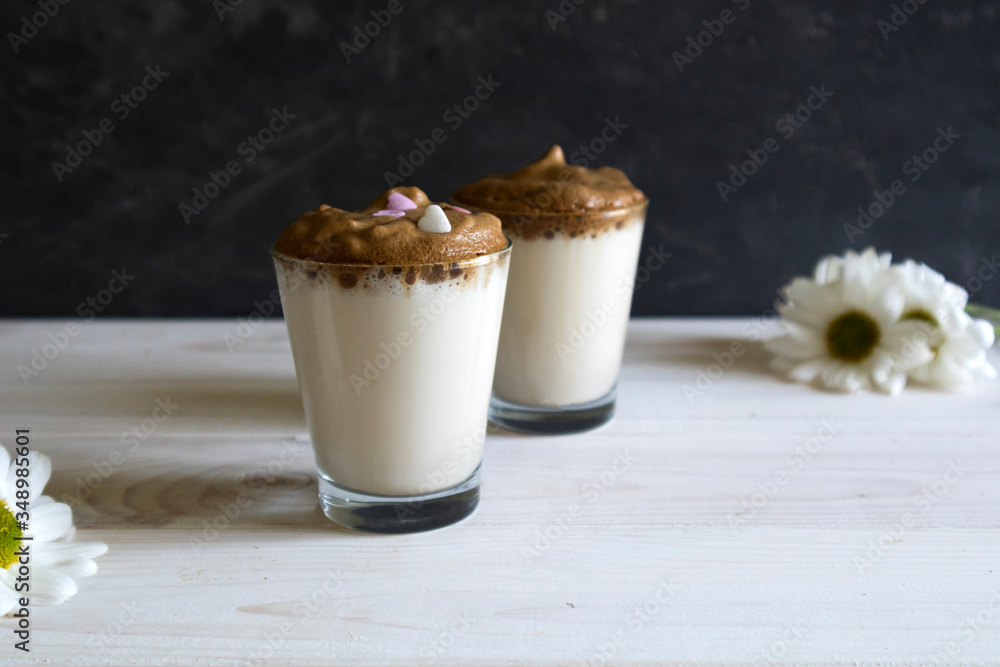 Dalgona coffee - the Korean coffee drink on wooden background, Dalgona coffee - instant coffee or espresso, whipped with sugar and hot water Dalgona coffee - the Korean coffee drink on wooden background, Dalgona coffee - instant coffee or espresso, whipped with sugar and hot water
