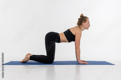 Sporty attractive young woman doing yoga practice on white background.