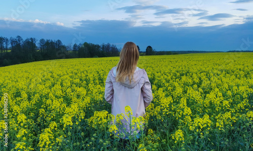 Beautiful blonde girl in a rape field before the storm. Photos from the back. © Irina Anashkevich