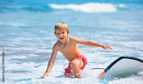 Photography Happy boy - young surfer learning ride, jump from surfboard with fun, run to beach