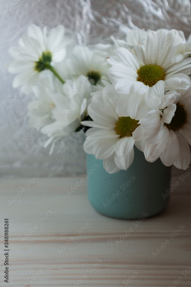 bouquet of chrysanthemums in a cup on a silver background close-up, white flowers, copy space.