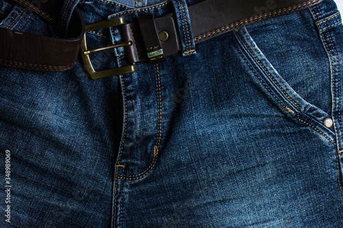jeans with a brown belt. Close up photo. Pictured pocket, zipper and belt