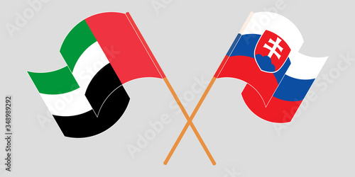 Crossed and waving flags of Slovakia and the United Arab Emirates
