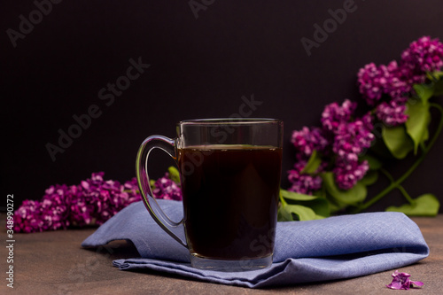 Cup with coffee on a table with flowers in the background
