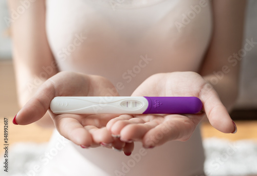 Close up of woman hand holding a positive home pregnancy test.