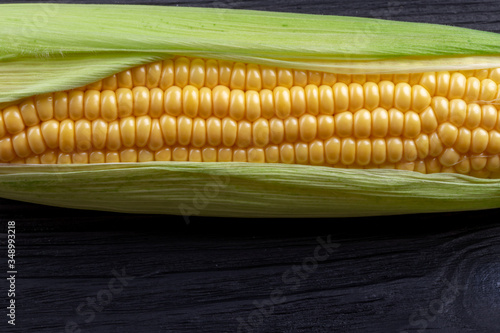 Ear of corn on a black wooden background.