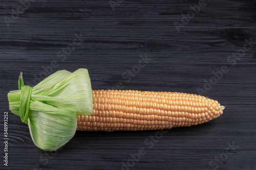 Ear of corn on a black wooden background.