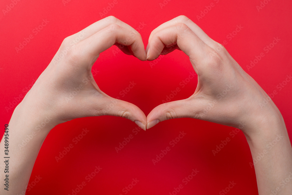Obraz premium Top pov above overhead close up view photo of woman making heart with her hands isolated on red background