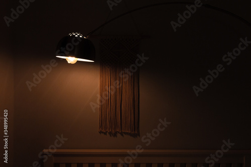 Light lamp in the bedroom shining in the night. Room decor by cotton tassel for wall hanging