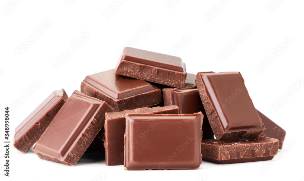 Pieces of milk chocolate heap on a white background. Isolated Pieces of milk chocolate heap on a white background. Isolated