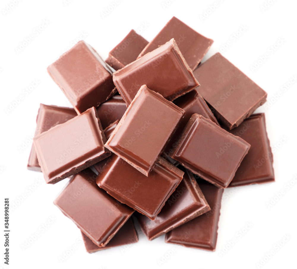 Pieces of milk chocolate heap on a white background. isolated. The view from top Pieces of milk chocolate heap on a white background. isolated. The view from top