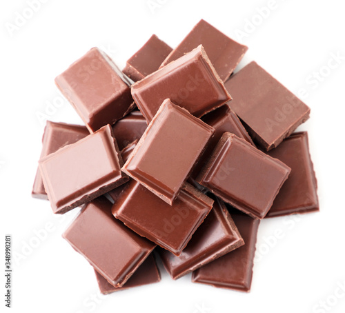 Pieces of milk chocolate heap on a white background. isolated. The view from top