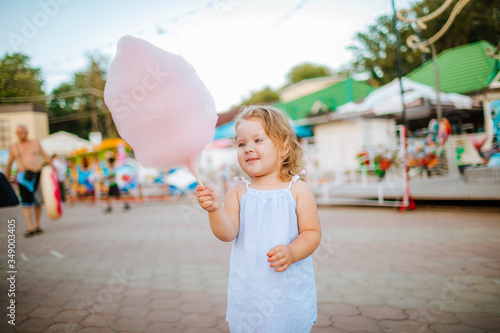 Cute little girl eating candy floss on a stick