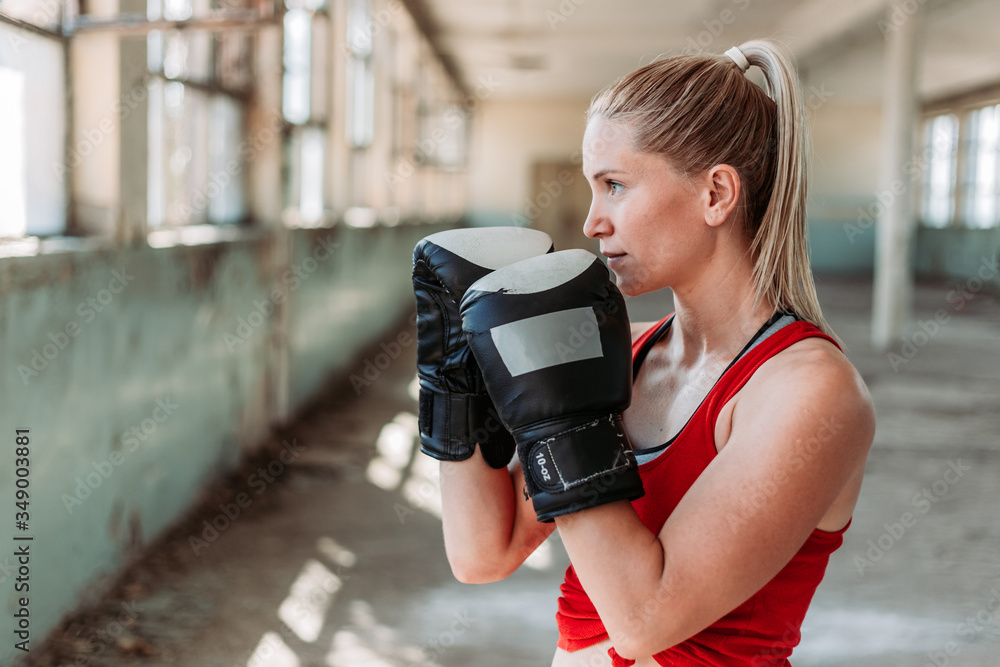 Indoors portrait of young, fit female boxer. Sport, active lifestyle. Copy space