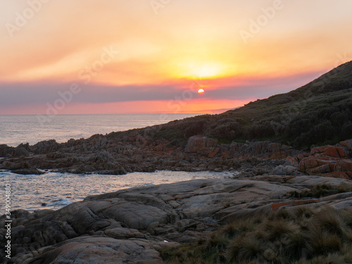 Sunset at rocky beachside view ocean waves