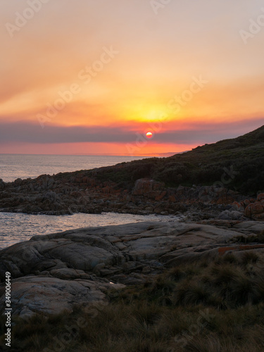Sunset at rocky beachside view ocean waves