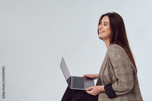 attractive business woman in a jacket sitting with a laptop and smiling