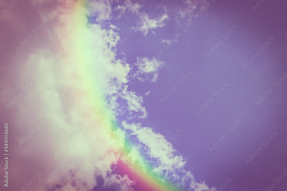 Piece of picturesque multicolored rainbow on the romantic purpuric sky. Clear afternoon day with white clouds. Background and wallpaper designer.