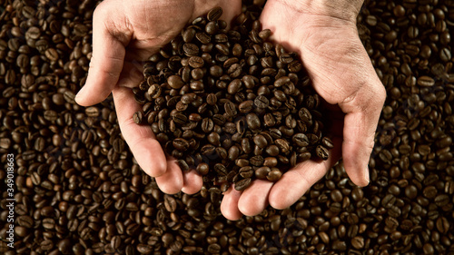 Detail of man hands holding coffee beans