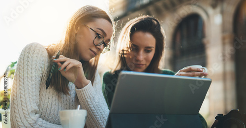 Photography woman communicate on design project, girls working on tablet in cafe outdoor, online shopping