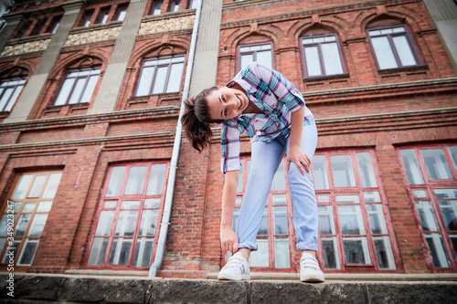 Wallpaper Mural Brunette funny pretty girl near wall with red brick in Central part of old city. Portrait of girl on street Torontodigital.ca