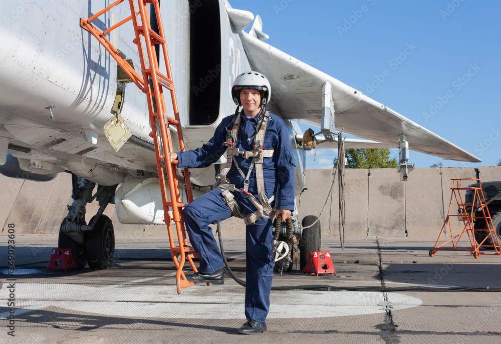 Military pilot in helmet stands near jet plane Military pilot in helmet stands near jet plane
