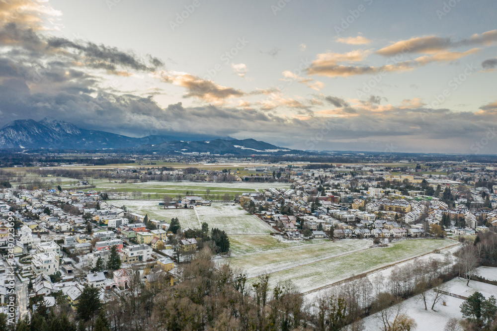 Aerial drone shot view of snowy villages outside Salzburg outskirt during sunset hour