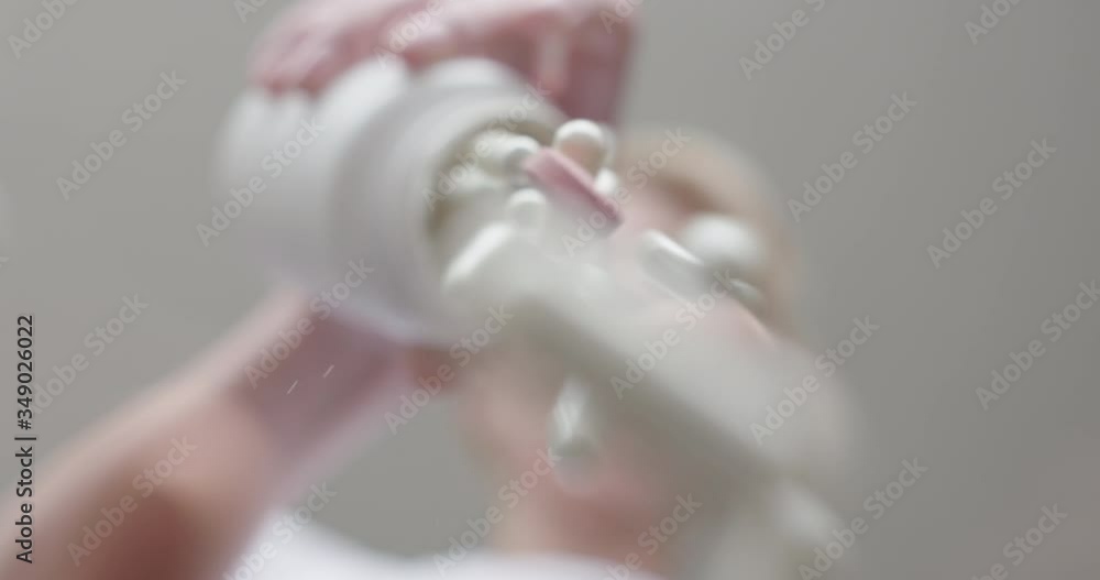 Woman pours many capsules on the camera. Woman pours many capsules on the camera.