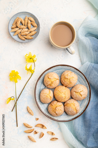 Almond cookies and a cup of coffee on a white concrete background Top view, close up.
