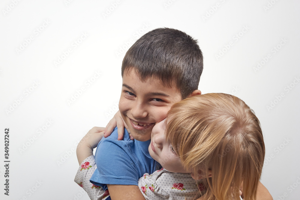 Portrait of adorable happy sister and brother hugs on a white background Portrait of adorable happy sister and brother hugs on a white background