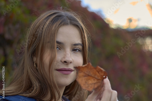 autumn portrait of a happy girl in the summer garden close up