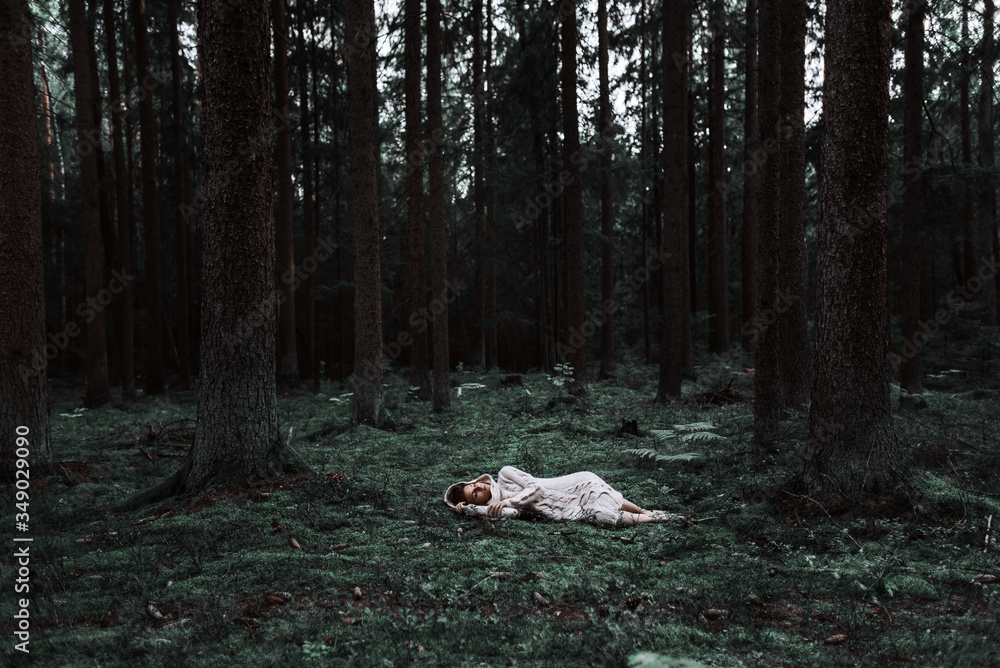 young girl sleeps in a forest in a knitted sweater. sleeping beauty in