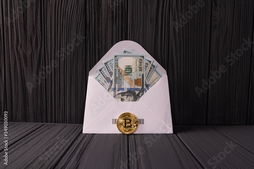 Golden Bitcoin Crypto currency coin near the envelope with dollar banknotes.