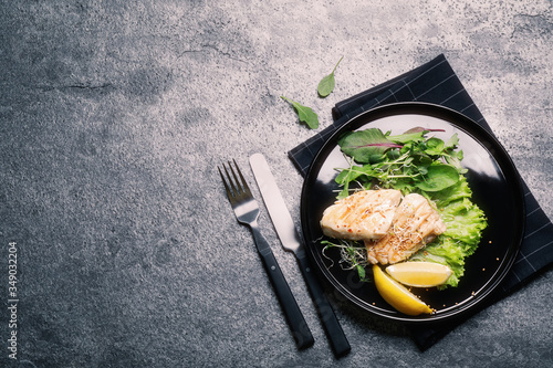 Tasty grilled fish on grey table, flat lay with space for text. Food photography