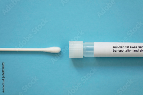 Virus testing swab and test tube on a blue background photo