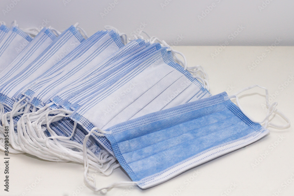 A pile of blue and white disposable face masks