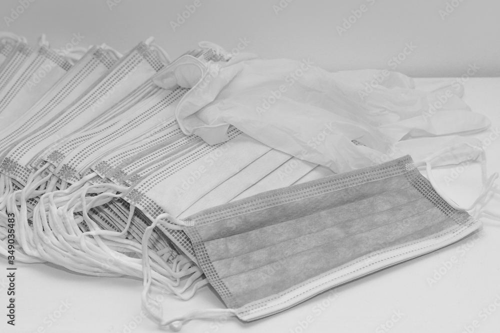 Black and white photo of disposable face masks and rubber gloves