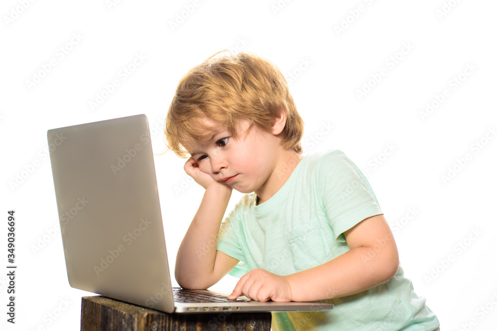 Learning concept. Boy spending time with notebook and modern technology. Little boy with laptop computer or notebook at home. Internet, homework and social media. Cute kid playing computer at home. Learning concept. Boy spending time with notebook and modern technology. Little boy with laptop computer or notebook at home. Internet, homework and social media. Cute kid playing computer at home.