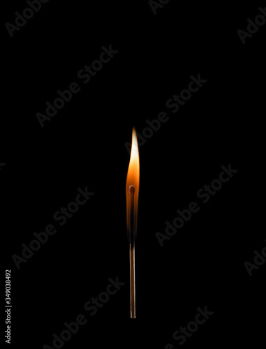 Burning match with a bright flame isolated on a black background