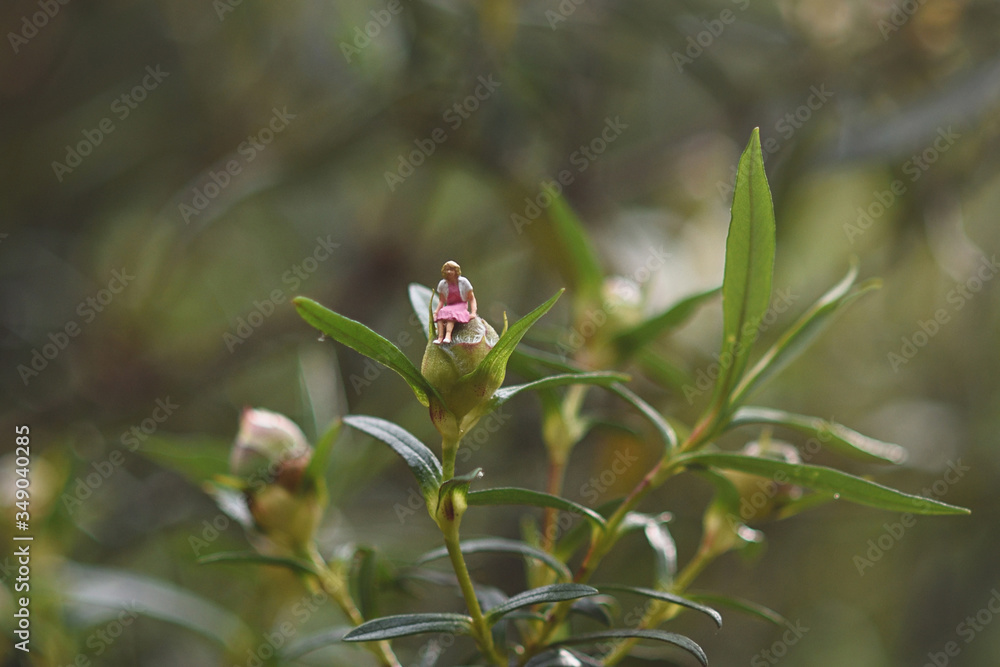 Woman sitting on a flower bud in the countryside, conceptual photo. Woman sitting on a flower bud in the countryside, conceptual photo.