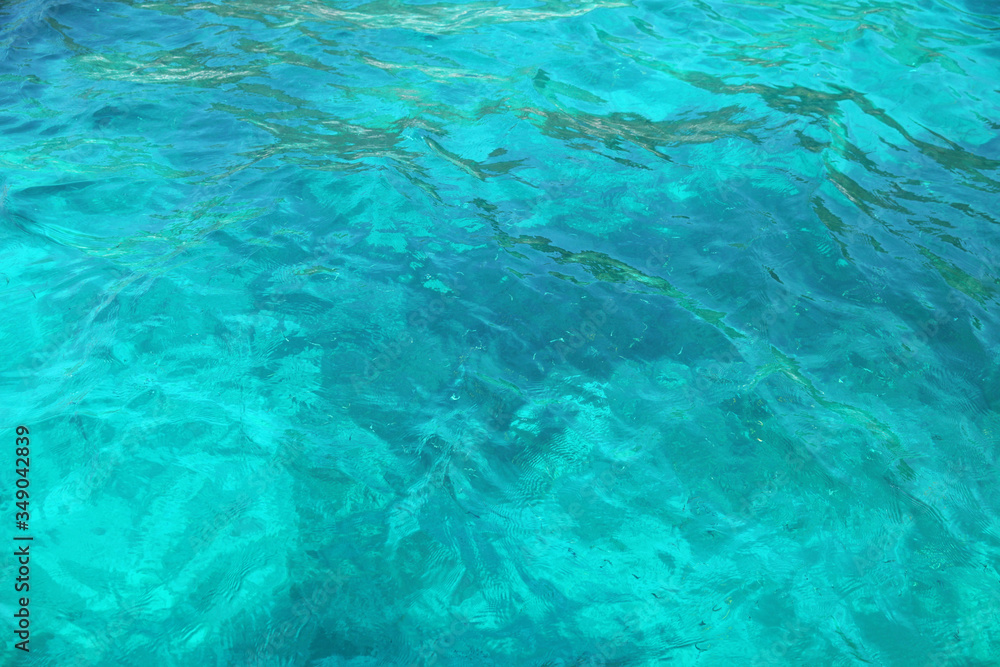 Fototapeta premium Blue glossy surface of the ocean with ripples and reflection of sunlight, selected sharpness