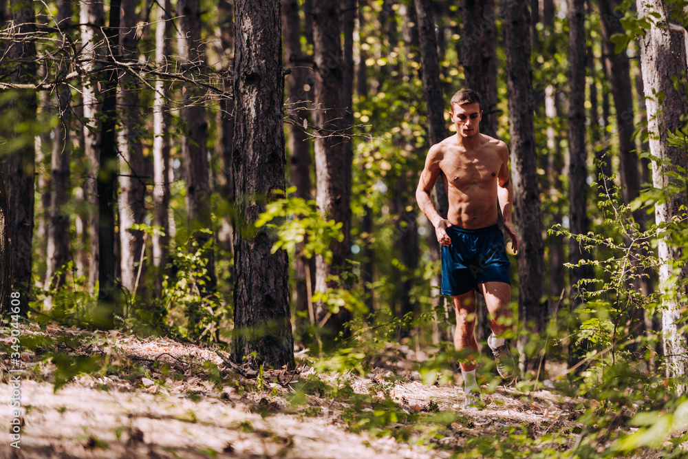 Crossfit shirtless man jogging on mountain trial Crossfit shirtless man jogging on mountain trial