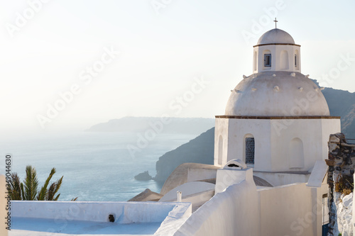 Little chapel 'Agios Minas' during last sun along the ocean, Fira, Santorini, Greece