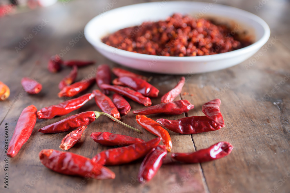 Dried chilies and chili sauce are on the wooden table Dried chilies and chili sauce are on the wooden table