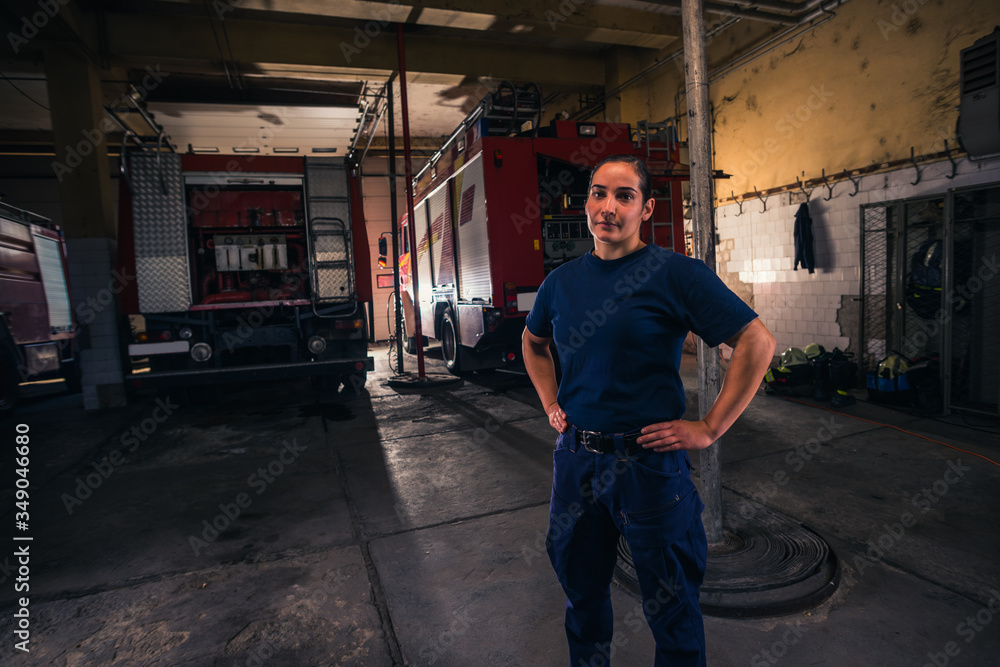 Portrait of female firefighter standing against firetruck at station Portrait of female firefighter standing against firetruck at station
