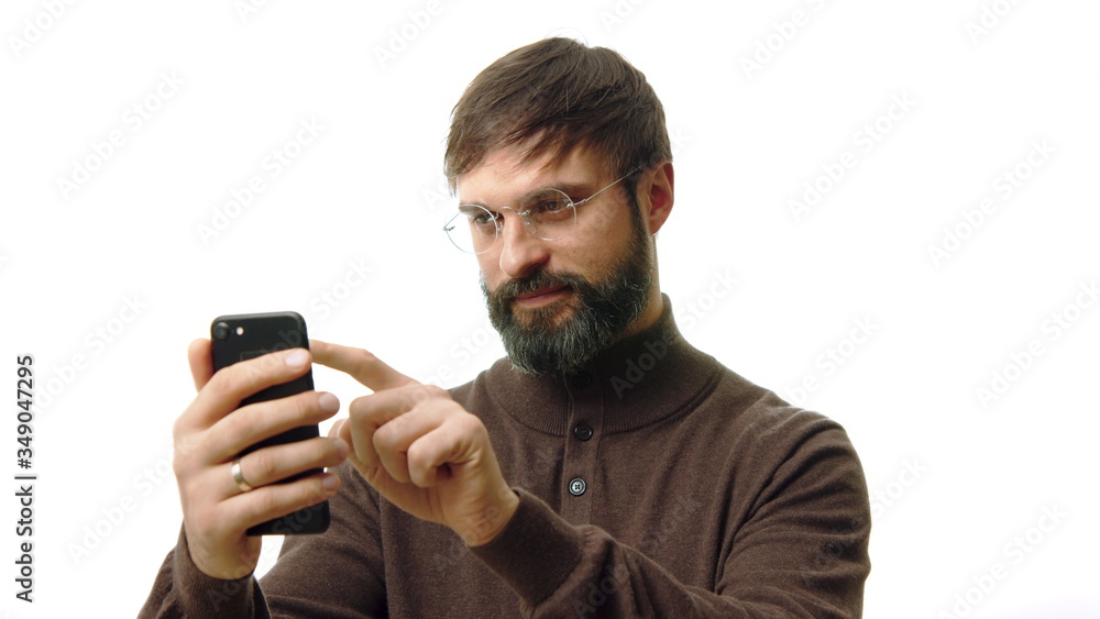 Confident businessman holding smartphone in hand and typing text message. Bearded man using cell phone on white background Confident businessman holding smartphone in hand and typing text message. Bearded man using cell phone on white background