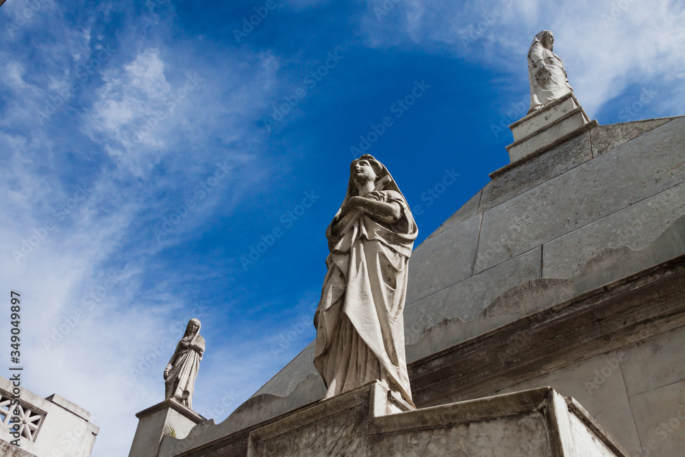 Three sculptures caring for a grave in the Recoleta cemetery in Buenos Aires