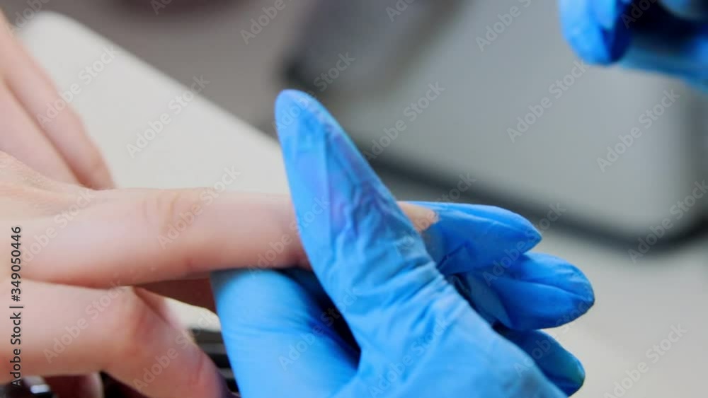 Master doing manicure - filing the nails in beauty salon Master doing manicure - filing the nails in beauty salon